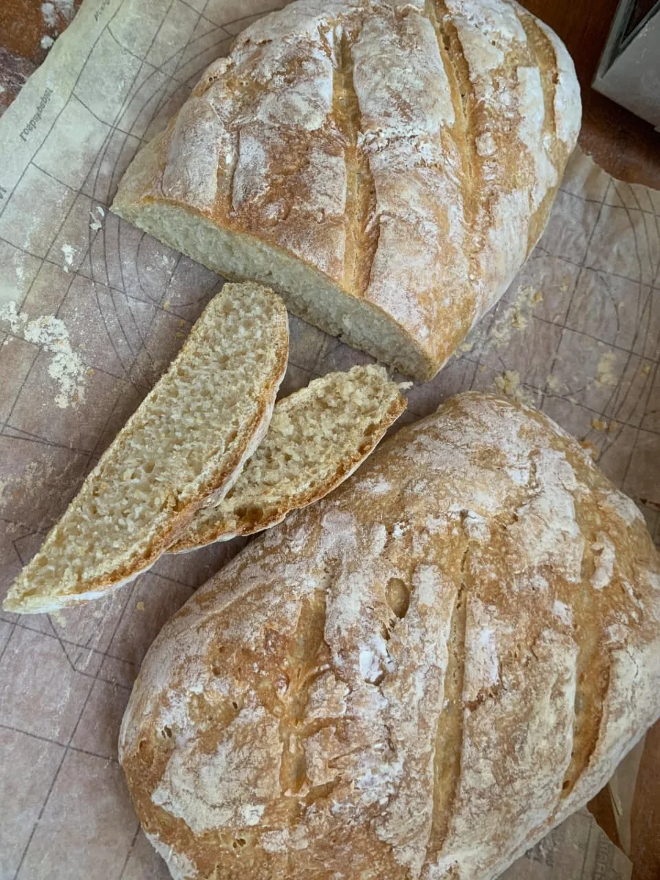 Flour-dusted artisan loaves with slices showing a soft crumb