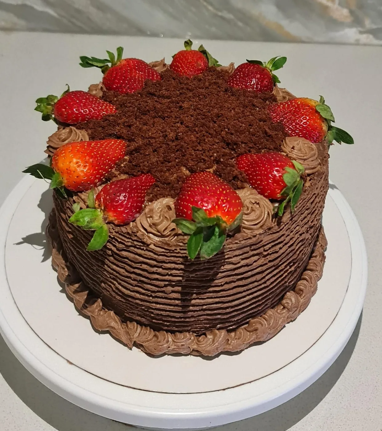 Chocolate buttercream cake with fresh strawberries and chocolate crumb