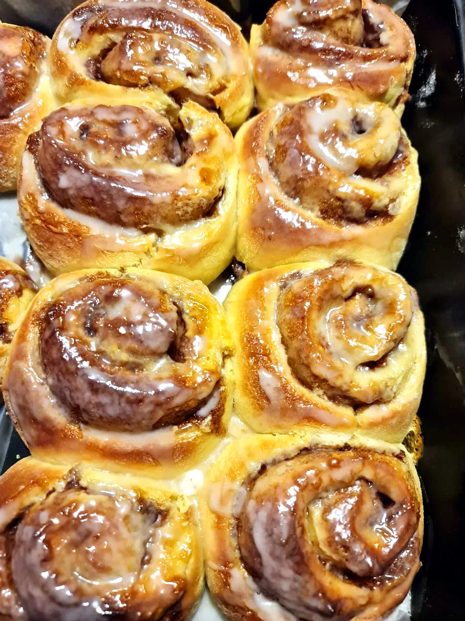 Tray of glazed cinnamon rolls, warm from the oven