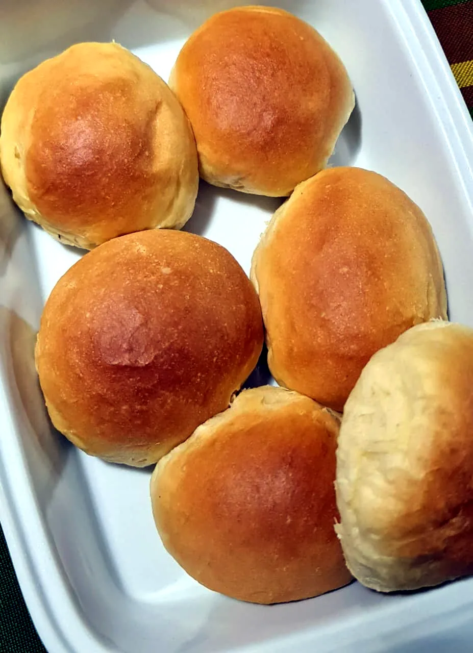Golden dinner rolls in a white dish