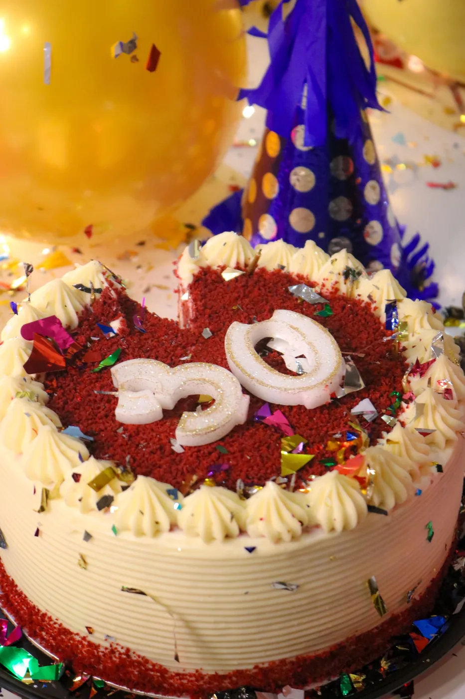 Red velvet cake with cream piping and a number 30 topper